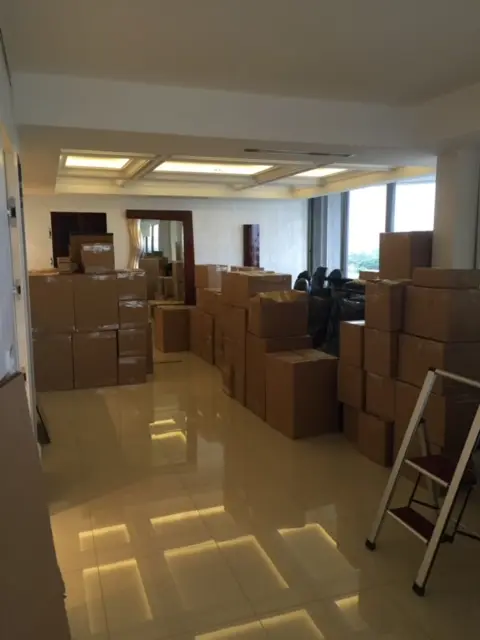 A room filled with boxes and a ladder.