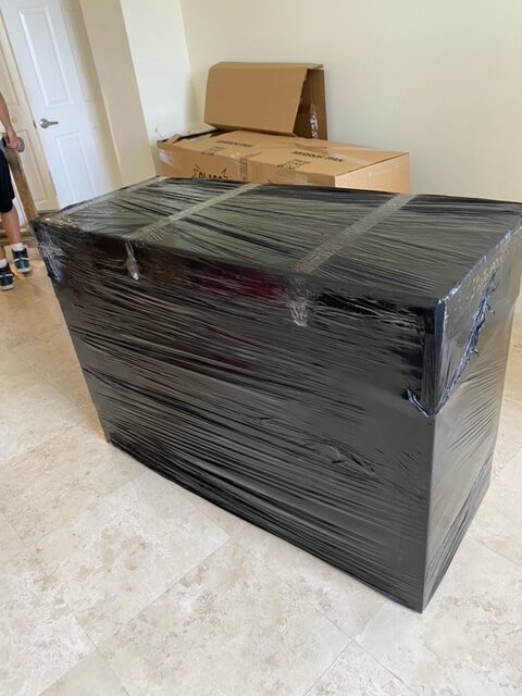 A black box is wrapped in plastic and ready for moving.